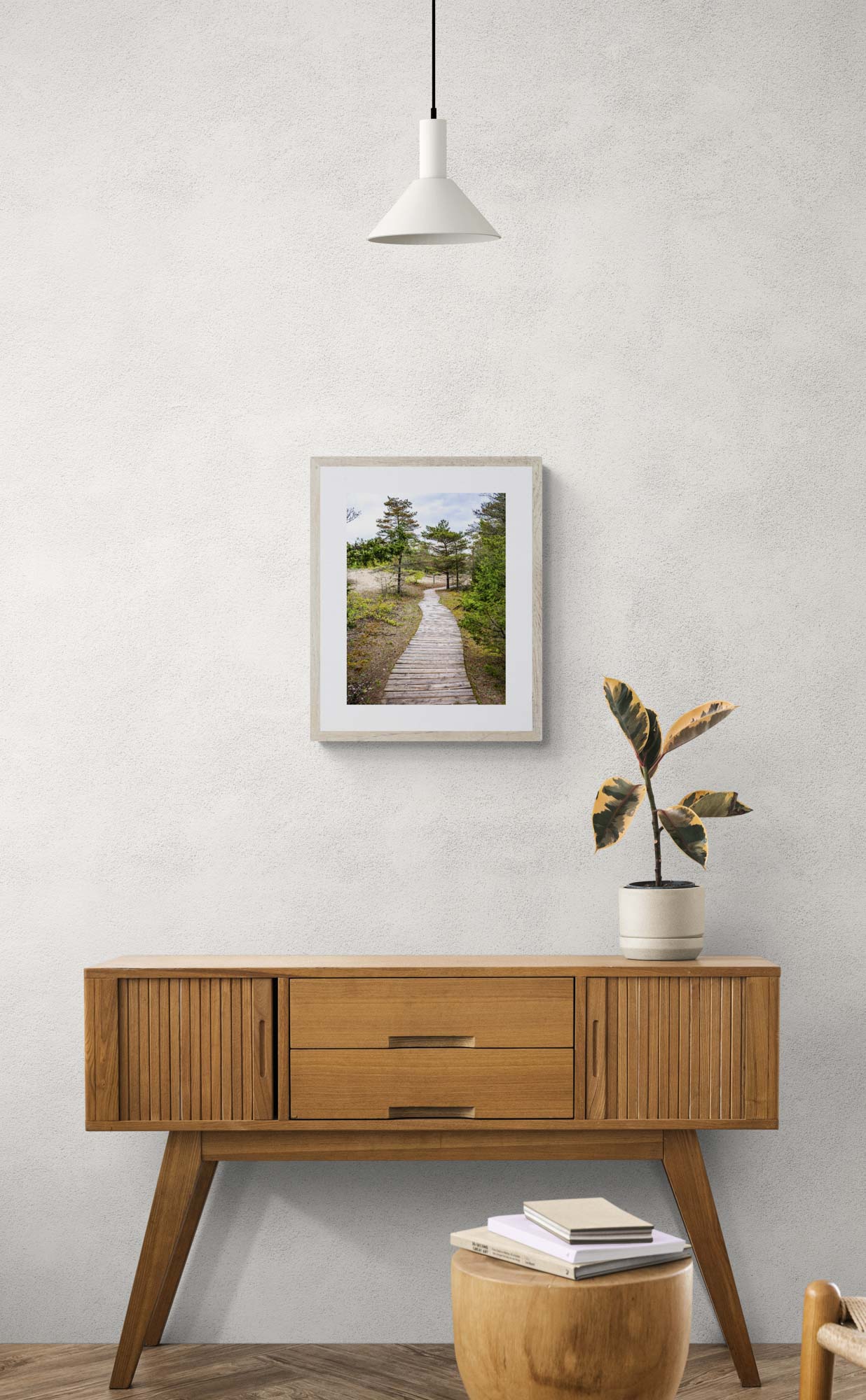 mockup photo of wooded forest path framed and hanging above wooden console table.